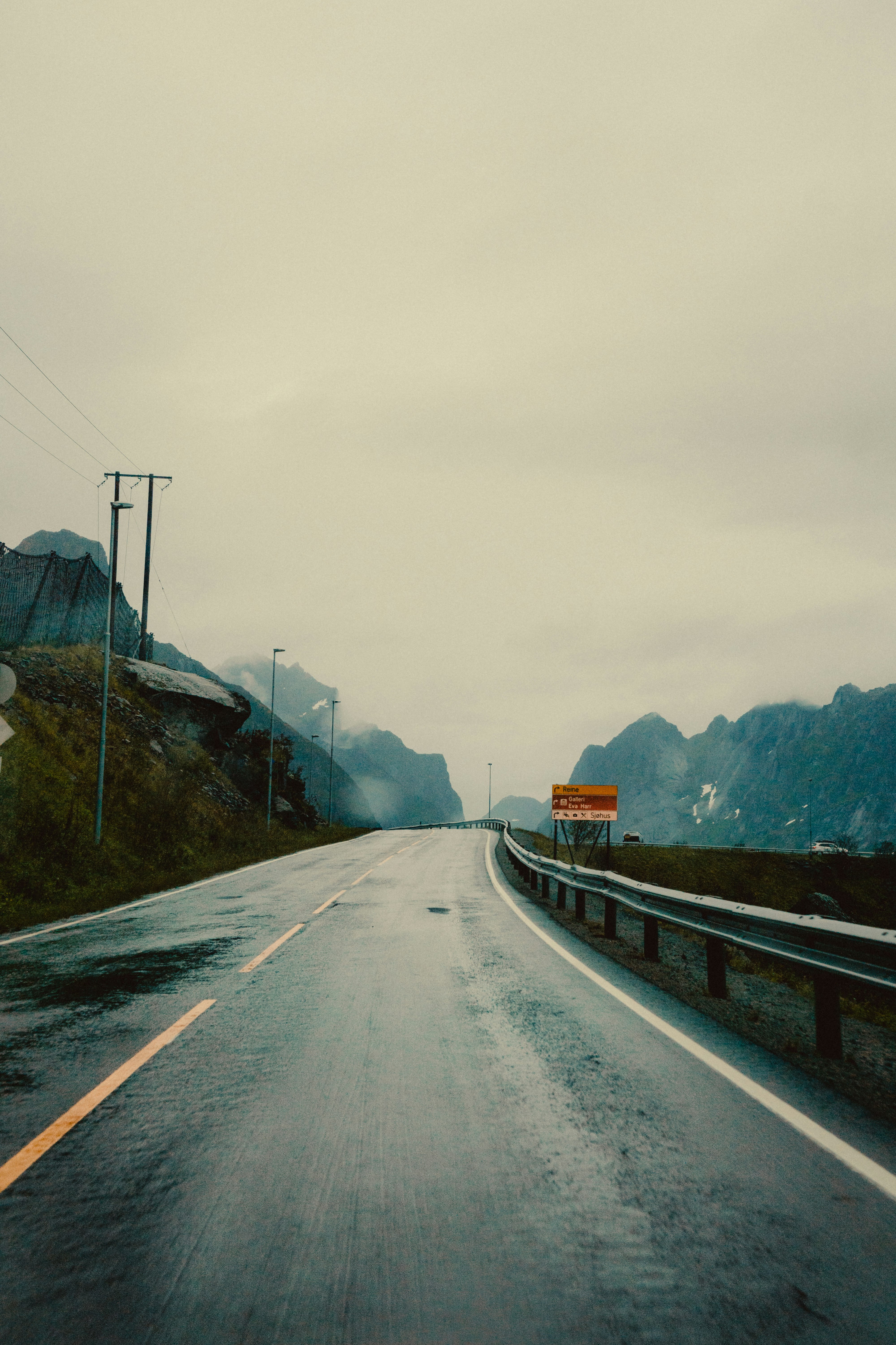 gray concrete road near mountain during daytime